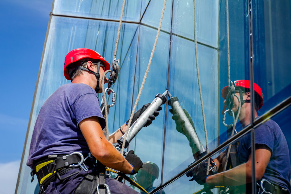 commercial-plumbing view on applying silicone sealant with gun on joints between windows